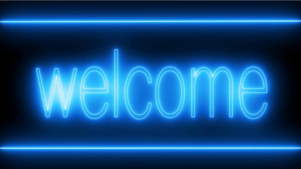 Neon "welcome" sign glowing blue on a dark background.
