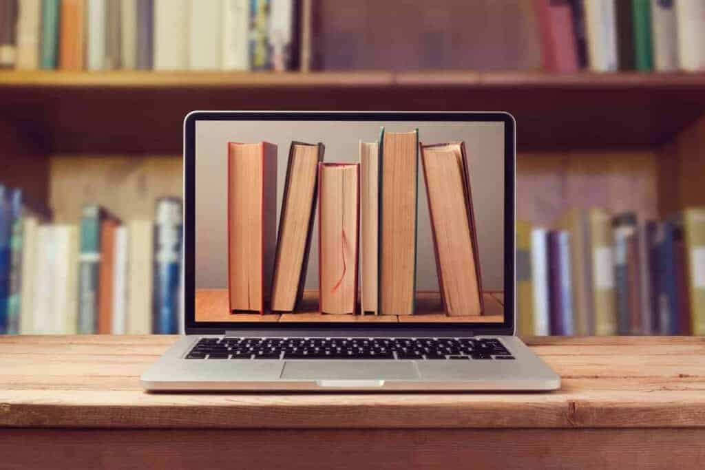 Bookshelf displayed on a laptop screen with classics and modern books in a library environment.
