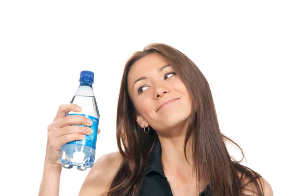 Image of a young woman marveling over her single-use plastic-bottled water.